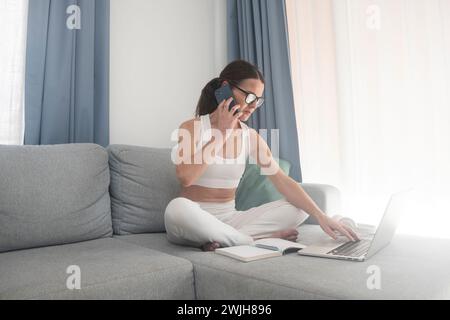 busy woman working from home on her phone and laptop Stock Photo