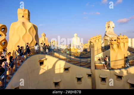 Roof of Casa Milà, La Pedrera, tourists on rooftop, terrace chimneys and vents at sunset, modernista architecture by Antoni Gaudí, Barcelona, Spain Stock Photo