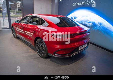 new red BYD Han EV 3.95, side view, Electric Vehicle Chinese manufacturer in Studio, elegance Car in showroom, Innovation in automotive industry show Stock Photo