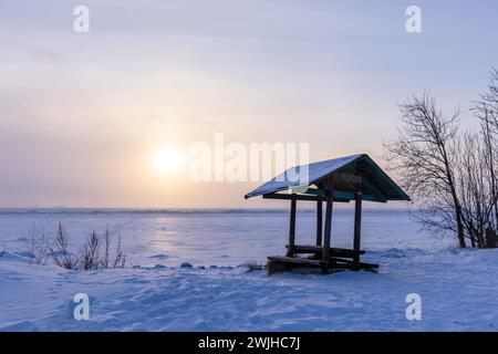 Winter landscape with an empty wooden gazebo on snow covered beach, natural background photo taken on the coast of the Gulf of Finland Stock Photo