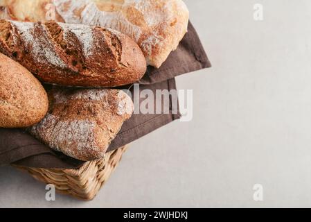 Assorted bakery products including loafs of bread,  baguette and rolls in basket, closeup Stock Photo
