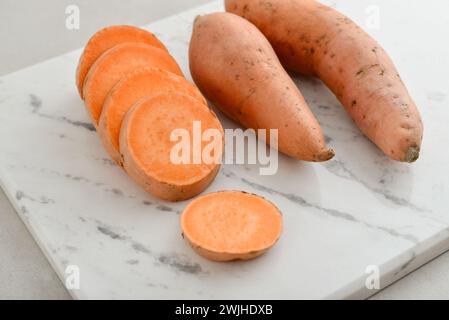 Set of fresh whole and sliced sweet potatoes  on light background. Stock Photo