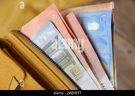 yellow leather wallet with EU banknotes, cash money on wooden table, finances in business and entrepreneurship concept, skillful personal finance mana Stock Photo