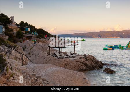 Straw beach umbrellas on the beach of Rabac, Croatian resort town on Kvarner Bay, just southeast of Labin, in Istria. Long a small fishing port, Rabac Stock Photo