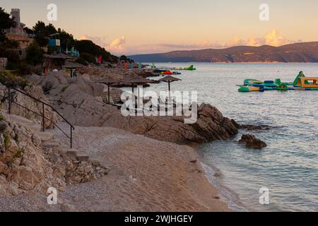 Straw beach umbrellas on the beach of Rabac, Croatian resort town on Kvarner Bay, just southeast of Labin, in Istria. Long a small fishing port, Rabac Stock Photo