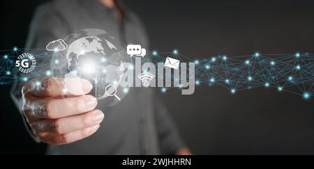 Global internet connection. Online digital data usage worldwide. Hand holds thumb drive with internet icons linked or connected to global electronics Stock Photo