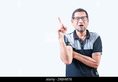 Shocked old man in glasses pointing at a advertising up. Surprised elderly man pointing up Stock Photo