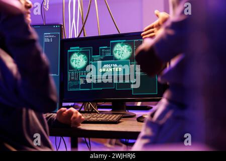 Access granted message on hackers computer screen after breaking into online server. Two criminals happy successful network system password hacking notification on monitor Stock Photo