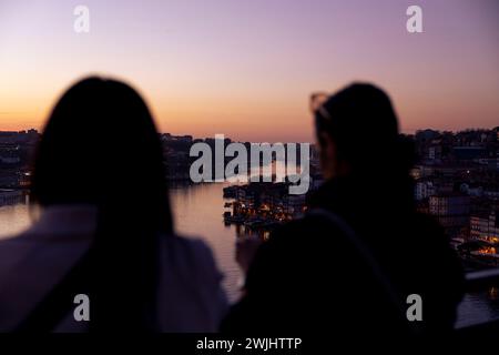 Silhouette of people watching the sunset over the Douro river in Porto, Portugal Stock Photo