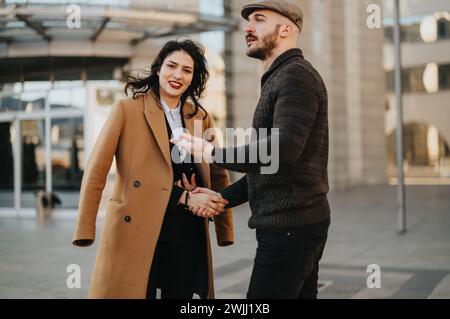 Stylish young couple walking and having a warm conversation in urban setting. Stock Photo