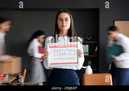 Young business woman with evacuation plan in office Stock Photo