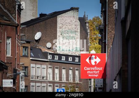 Picture of a sign with the logo of Carrefour market in front of their local store in downtown Liege, belgium. Carrefour market is a chain of proximity Stock Photo