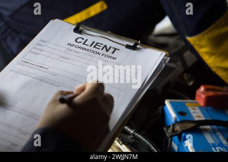 A man holds a clipboard featuring a form with client detail, ready to be filled out. Stock Photo