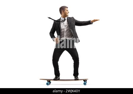 Businessman in a black suit riding a skateboard isolated on white background Stock Photo