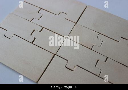 Rectangular panel of tightly folded plywood puzzles on a white surface Stock Photo