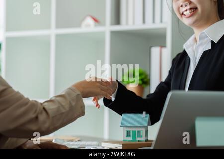 Real estate agent talked about terms of the home purchase agreement and asked the customer to sign the documents to make the contract legally Stock Photo