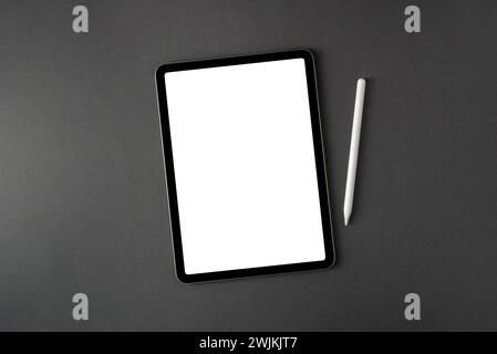 Tablet with blank screen and stylus on dark gray office desk Stock Photo