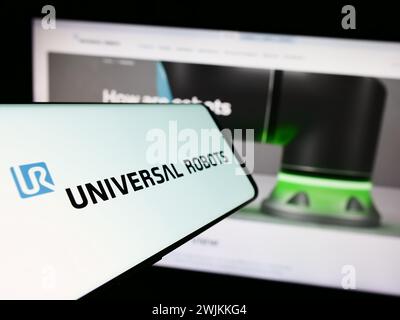 Cellphone with logo of Danish cobot company Universal Robots AS in front of business website. Focus on center-left of phone display. Stock Photo