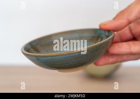 Handmade ceramic ramekin held by human hand. High quality photo Stock Photo