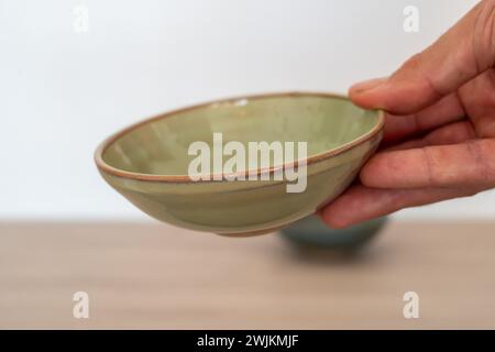 Handmade ceramic ramekin held by human hand. High quality photo Stock Photo