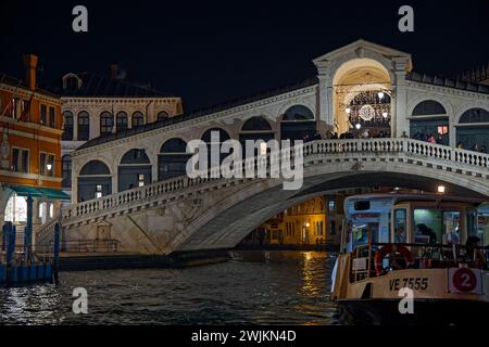 VENICE, ITALY, February 1, 2024 : Vaporetto station at the foot of famous Rialto bridge on Grand Canal at night Stock Photo