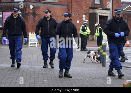 Police officers carry out security sweeps ahead of the Requiem Mass for former Rochdale MP and Greater Manchester mayor Tony Lloyd, at St Hugh Of Lincoln RC Church in Stretford, Manchester, following his death on January 17. Picture date: Friday February 16, 2024. Stock Photo