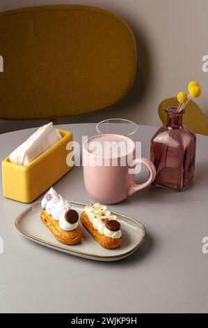 eclairs on a plate and coffee in a coffee shop on the table Stock Photo