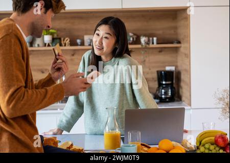 Adult couple shopping online on smart phone and laptop Stock Photo