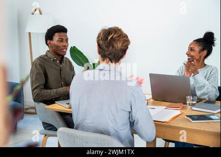 Businessman talking with colleagues while they are clapping hands Stock Photo