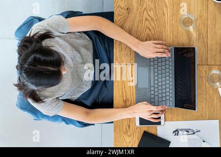 Advertising agency worker using laptop while sitting at desk Stock Photo