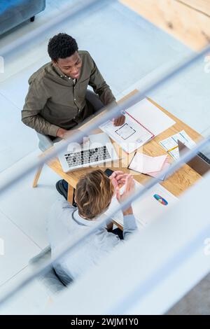 Businessmen discussing work while at desk using laptop Stock Photo