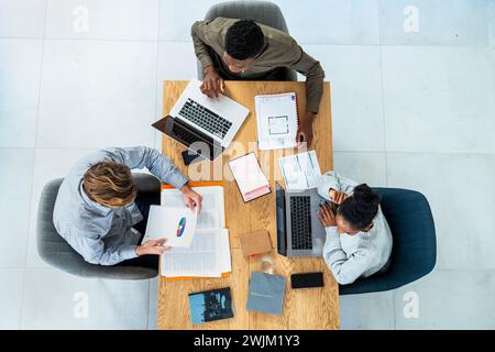 Financial team sitting at desk while working on project Stock Photo