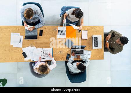 Advertising agency workers sitting at table using laptop Stock Photo