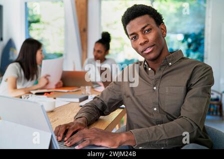 Head manager working at desk while using digital tablet looking at the camera Stock Photo