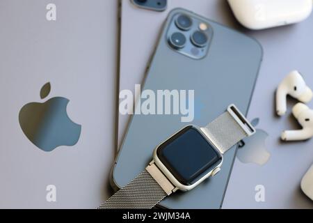 KYIV, UKRAINE - 4 MAY, 2023: Apple brand devices iphone, ipad and airpods with apple watch lies on macbook body close up Stock Photo