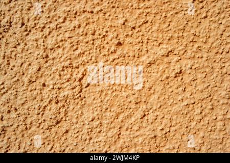 Textured plaster on a wall in the color orange, texture background Stock Photo