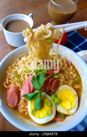 Photo of noodle soup with toppings such as sausages, eggs, and vegetables Stock Photo