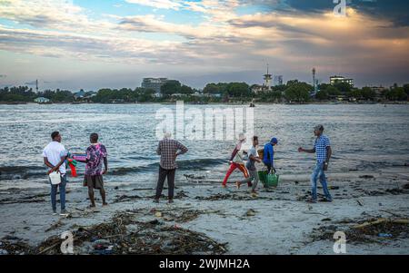 Porters run with bags of fish after unloading the catch from traditional wooden dhow boats in the evening at Kivukoni Fish Market, Dar es Salaam, Tanz Stock Photo