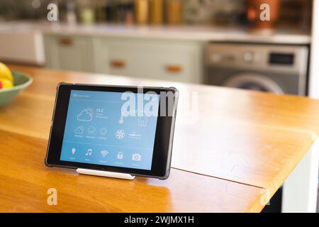 A tablet displays a smart home interface in a modern kitchen Stock Photo