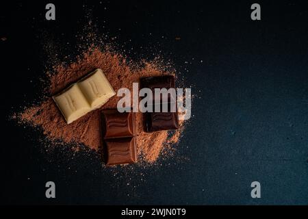 White,Dark and Milk chocolate on cocoa powder Stock Photo