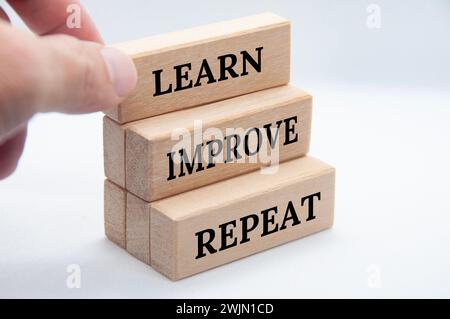 Learn, improve and repeat text on wooden blocks with white cover background. Improvement concept Stock Photo