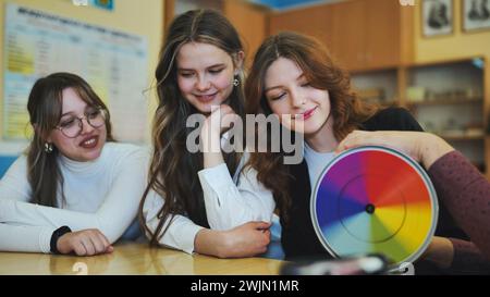 Students in physics class spin Newton's multicolored disk. Stock Photo
