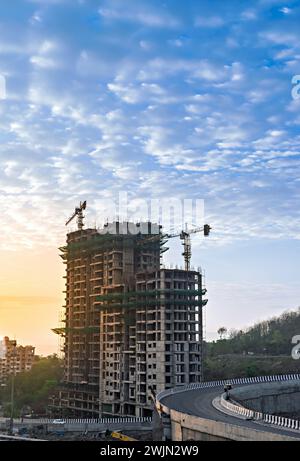 Image of tall buildings under construction with Sunrise in sky in background at Pune, Maharashtra. Stock Photo