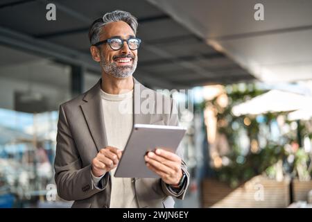Happy middle aged professional business man executive manager using tablet. Stock Photo