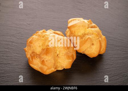 Two delicious éclairs on slate stone, close-up. Stock Photo