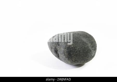 Dark gray stone from the bottom of the sea on a white background. Stock Photo