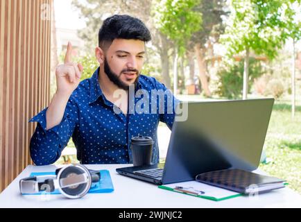 Businessman working at laptop, using webcam. Stock Photo