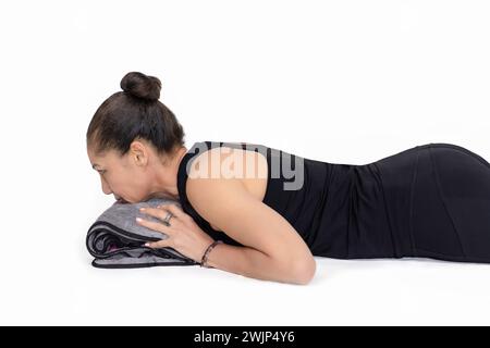 Specialized trauma yoga and Pilates exercises for elderly people on the floor, middle woman trainer posing with head on a towel. In the studio isolate Stock Photo