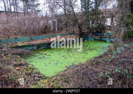 Old pool fountain winter ditch water in winter time post apocalyptic scene in an abandoned factory Stock Photo