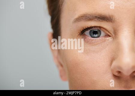 close up of appealing woman with blonde hair looking at camera with contact lense on her eye Stock Photo